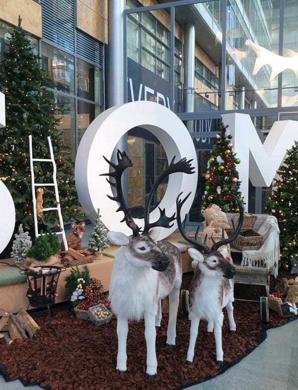 Maatwerk kerstdecoratie met groene kerstbomen en rendieren in entree bedrijf